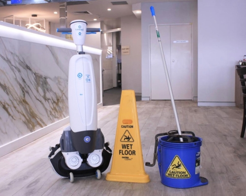 i-mop floor scrubber with a caution wet floor sign and mop and bucket